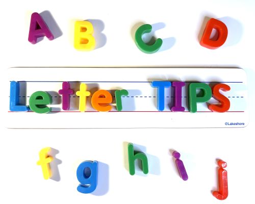 Colored plastic letters on top of a whiteboard.